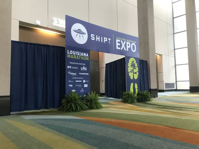 Louisiana Marathon Expo entrance arch with branded signage and striped event carpet